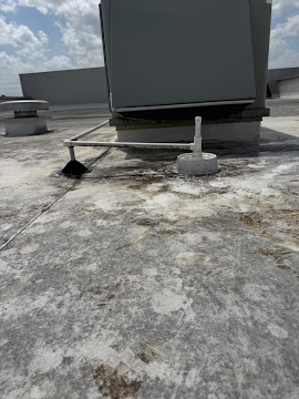 Rooftop package unit and condensate drain on a commercial roof